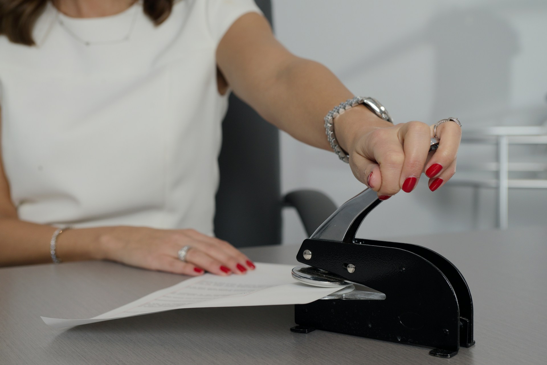 A paper is being embossed with a notary stamp